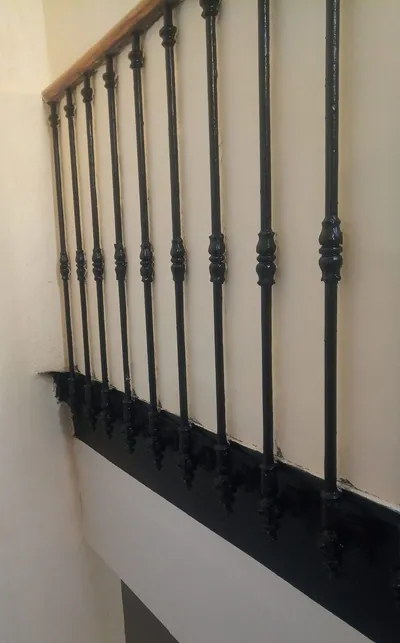Gros plan sur des barreaux en fer forgé laqués noir brillant