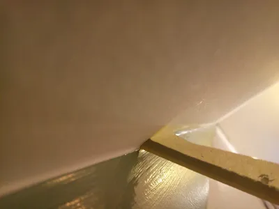 Gros plan sur la finition d'un angle au mastic avant peinture