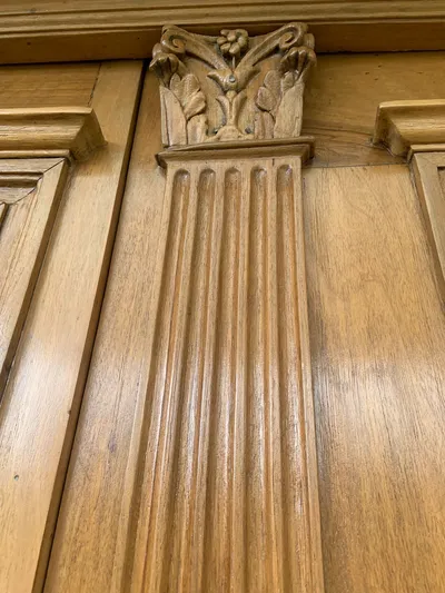 Détail d'un pilastre en bois sculpté sur un panneau lambris fraîchement verni