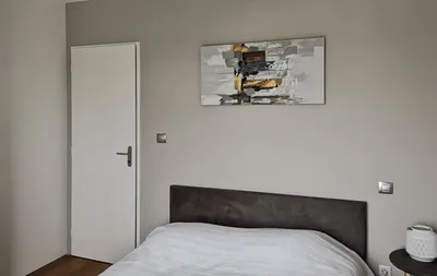 Chambre avec mur taupe clair et porte blanche laquée, vue rapprochée