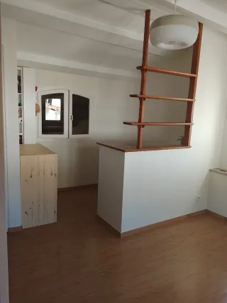 Attic room with white painted ceiling and beams, wooden floor