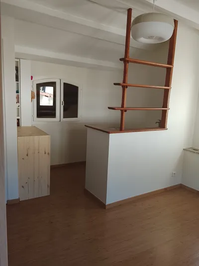 Combles avec plafond et poutres peints en blanc, sol en bois
