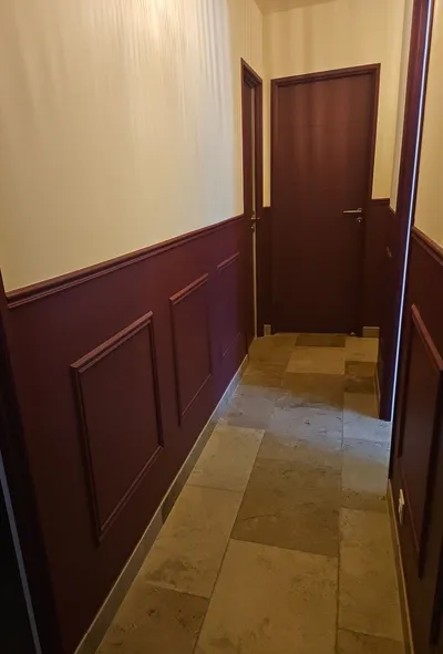 Couloir repeint en bicolore, lambris bordeaux et partie haute crème, sol carrelé