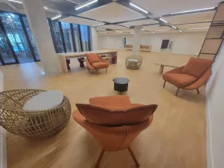 Painted white lounge area with terracotta armchairs and large glazed windows