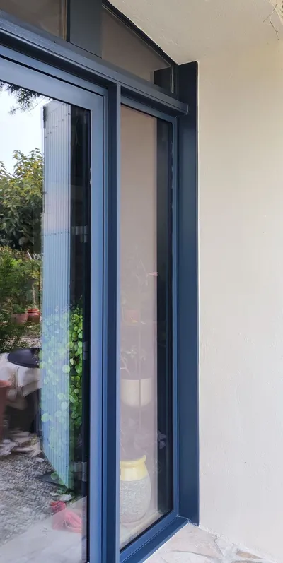 Gros plan sur l'angle d'une menuiserie laquée anthracite en façade