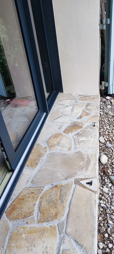 Détail d'une menuiserie laquée anthracite au ras d'un seuil en pierre
